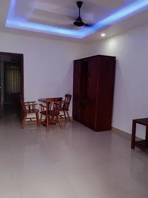 a dining room with a table and chairs and a cabinet at Mscb guest house in Idukki