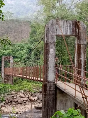 a man standing on a bridge over a river at Mscb guest house in Idukki