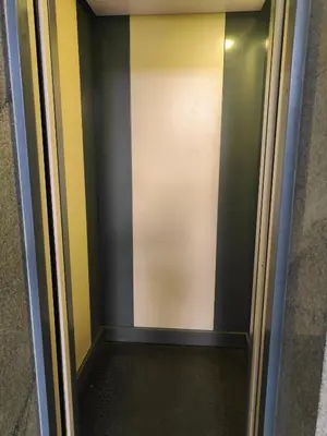 an elevator with a door with black and yellow stripes at Suyog Apartments in Mysore