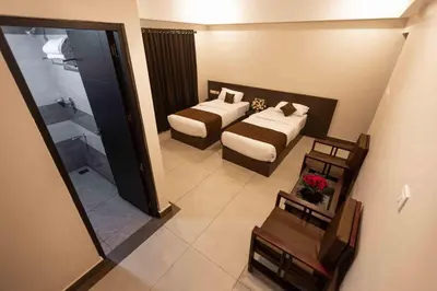 a hotel room with two beds and a bathroom at HOTEL PANKAJ RESIDENCY in Guruvāyūr