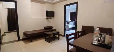a living room with a table and a bench in a room at HOTEL PANKAJ RESIDENCY in Guruvāyūr