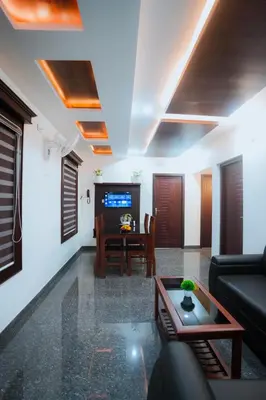 a living room with a couch and a table at BEVERLY SUITES in Wayanad