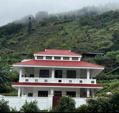 a white building with a red roof on a hill at ATTUVAM VISTA in Kodaikānāl