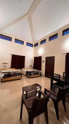 a large room with two beds and chairs in it at ATTUVAM VISTA in Kodaikānāl