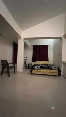 a bedroom with a bed and a chair in a room at ATTUVAM VISTA in Kodaikānāl