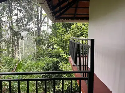 a balcony of a house with a view of trees at Deesha Homes in Wayanad