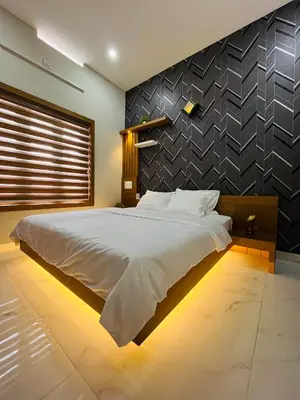 a bedroom with a large bed with a black wall at Milaano Orchids, Service Villa, Kammana Mananthavady in Wayanad