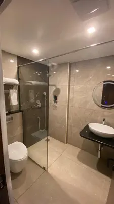 a bathroom with a shower and a toilet and a sink at The Zen Park Coimbatore in Coimbatore