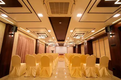 a conference room with white chairs and a table at The Zen Park Coimbatore in Coimbatore