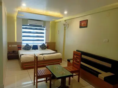 a bedroom with a bed and a table and a window at Royal Plaza Residency in Cheruppulasseri