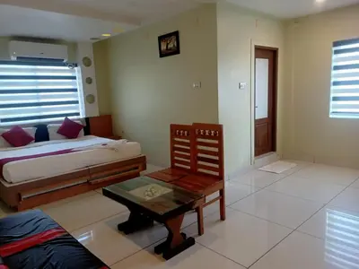 a bedroom with a bed and a table in it at Royal Plaza Residency in Cheruppulasseri