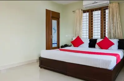a bedroom with a large bed with red pillows at MP RESIDANCY in Perintalmanna