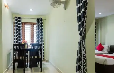 a room with a table and chairs and a bed at MP RESIDANCY in Perintalmanna