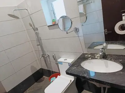 a bathroom with a sink and a toilet and a mirror at Coorg Vismaya in Madikeri