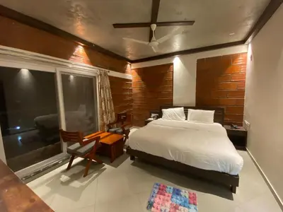 a bedroom with a bed and a large window at Coorg Vismaya in Madikeri