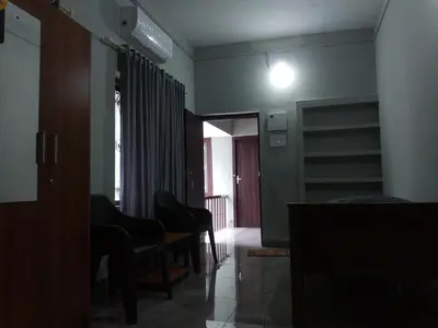 a living room with chairs and a light on the wall at Malapuram quarters in Malappuram
