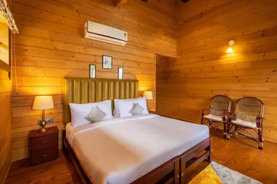 a bedroom with a bed in a wooden room at amã Stays & Trails The Malabar Villa Heliconia, Kozhikode in Wayanad