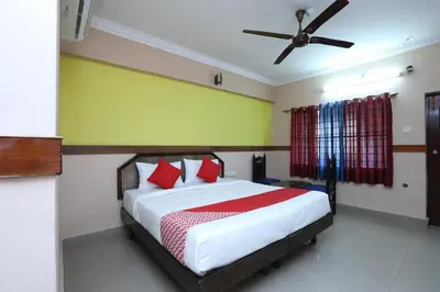 a bedroom with a bed and a ceiling fan at Hotel O SK Regency in Mysore