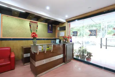 a bar in a restaurant with a red chair at Hotel O SK Regency in Mysore