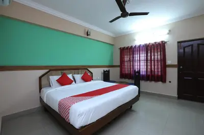 a bedroom with a large bed with red pillows at Hotel O SK Regency in Mysore