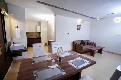 a living room with a table and a couch at Lantern Apart Hotel in Perintalmanna