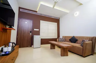 a living room with a couch and a table at Lantern Apart Hotel in Perintalmanna