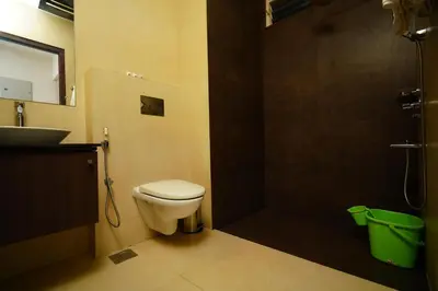 a bathroom with a toilet and a sink and a shower at Lantern Apart Hotel in Perintalmanna