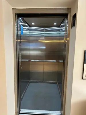 a elevator in a room with a glass door at Lantern Apart Hotel in Perintalmanna