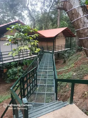 a building with a staircase leading up to it at Devi Villa - Plantation Retreat and Forest Getaway in Kutta
