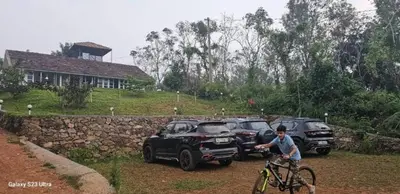 a man riding a bike next to parked cars at Fortune Clio Resort in Periya