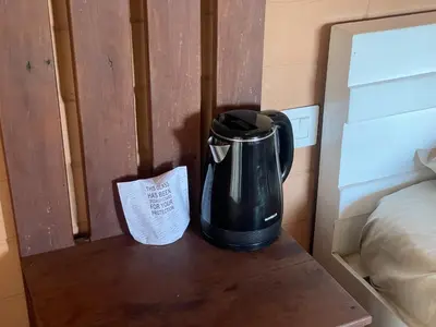 a coffee pot sitting on a table next to a bed at Fortune Clio Resort in Periya