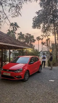 a red car parked in a gravel parking lot at Crossroads Hostel 1957 in Wayanad
