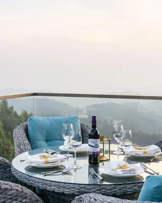a table with a bottle of wine and glasses at Stays By MindEscapes in Ketti