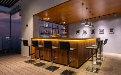 a bar with black stools in a room at Stays By MindEscapes in Ketti