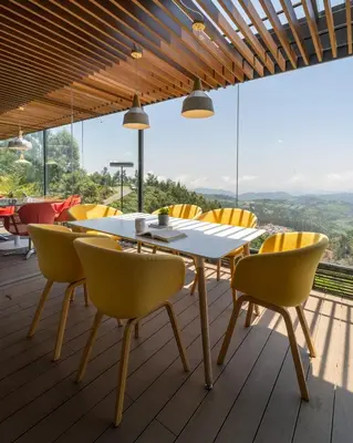 a dining room with a white table and yellow chairs at Stays By MindEscapes in Ketti