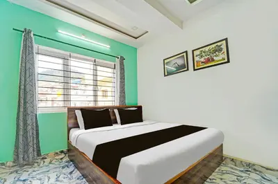 a bedroom with a large bed with a green wall at Super Hotel O Vijaynagar Road Formerly Anmol Peace Stay in Ooty