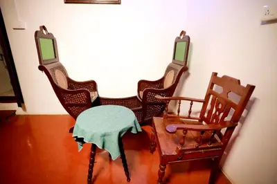 a group of chairs with a table in a room at Srivilas in Pudunagaram