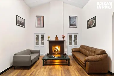 a living room with a couch and a fireplace at StayVista at The Alcove with Breakfast & BBQ Grill in Ooty