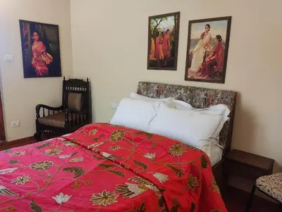 a bedroom with a bed with a red blanket at Habba Kadal Kashmiri Heritage Hotel & Hub in Coonoor