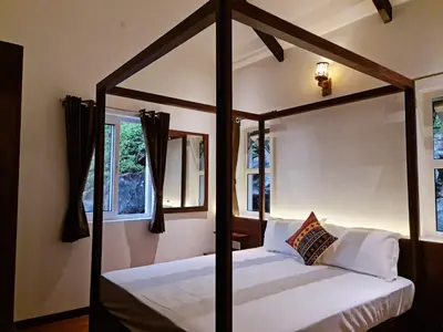 a four poster bed in a room with windows at Sky Sketch in Kodaikānāl