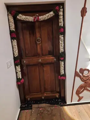 a wooden door with a garland of pink flowers at Sky Sketch in Kodaikānāl