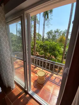 a sliding glass door with a view of a balcony at FernHills Homestay in Madikeri