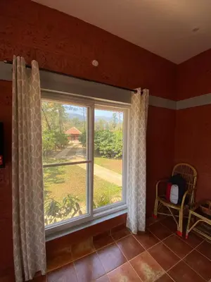 a window in a room with a view of a yard at FernHills Homestay in Madikeri