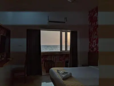 a bedroom with a window with a view of the ocean at Cherai Blue View Beach Resort in Cochin