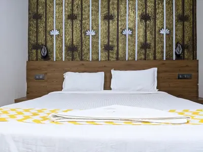 a bedroom with a white bed with a wooden headboard at Cherai Blue View Beach Resort in Cochin