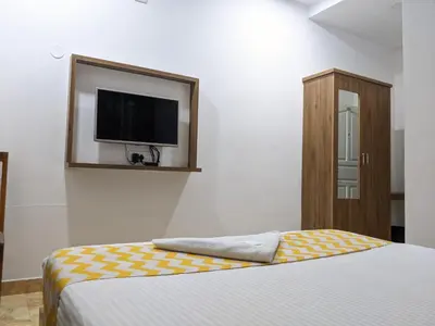 a bedroom with a bed and a flat screen tv at Cherai Blue View Beach Resort in Cochin