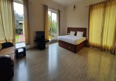 a bedroom with a bed and a television in it at Velus Bungalow Ooty in Ooty