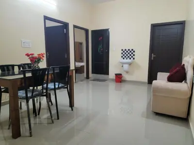 a living room with a table and chairs and a couch at Fathima Apartments in Iritti