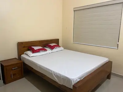 a bedroom with a bed and a window with a blind at Fathima Apartments in Iritti
