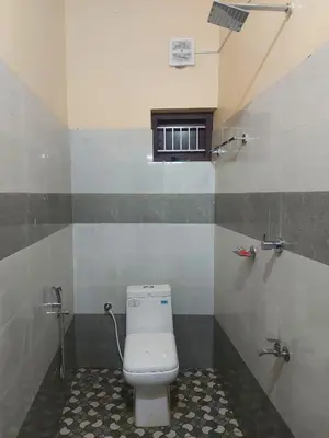 a bathroom with a white toilet and a window at Fathima Apartments in Iritti